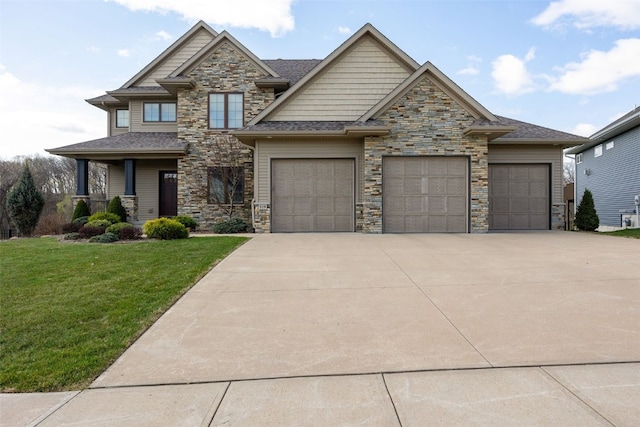 919 Camp Cardinal Rd, Iowa City, IA 52246 - craftsman inspired home with a shingled roof, concrete driveway, stone siding, a front yard, and a garage