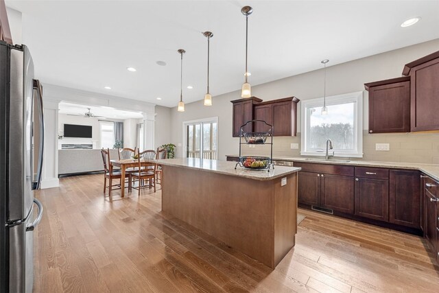 919 Camp Cardinal Rd, Iowa City, IA 52246 - kitchen featuring a ceiling fan, a sink, decorative backsplash, light wood finished floors, and freestanding refrigerator