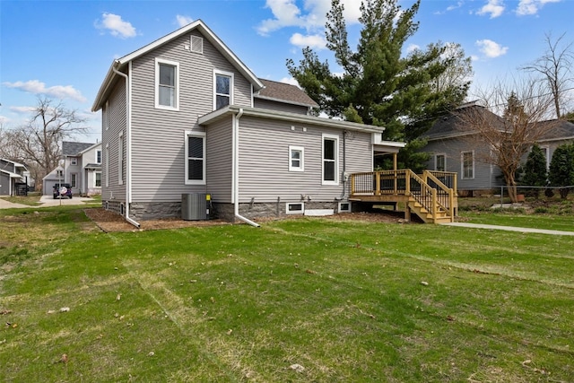back of property with a wooden deck, a lawn, and central air condition unit