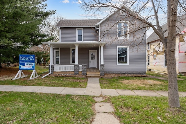 view of front of house with covered porch and a front yard