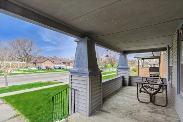 wooden deck featuring covered porch and a residential view