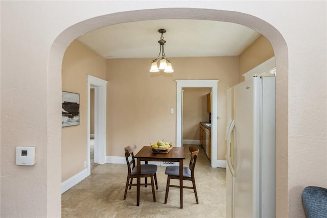 dining room featuring arched walkways and a notable chandelier
