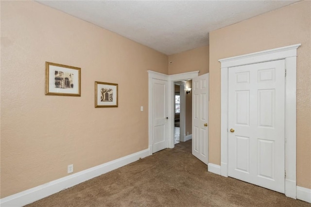 unfurnished bedroom featuring carpet floors and baseboards