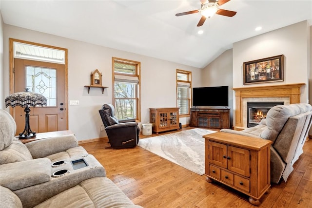 living room with light wood-style flooring, a ceiling fan, a fireplace, lofted ceiling, and recessed lighting
