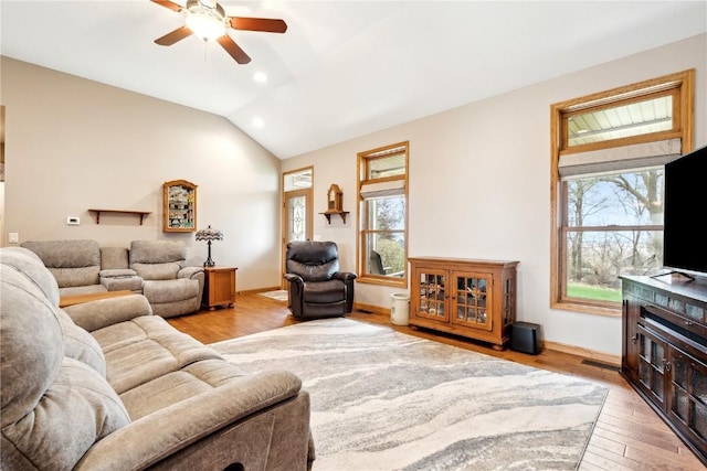 living room with a ceiling fan, light wood-style floors, recessed lighting, vaulted ceiling, and baseboards