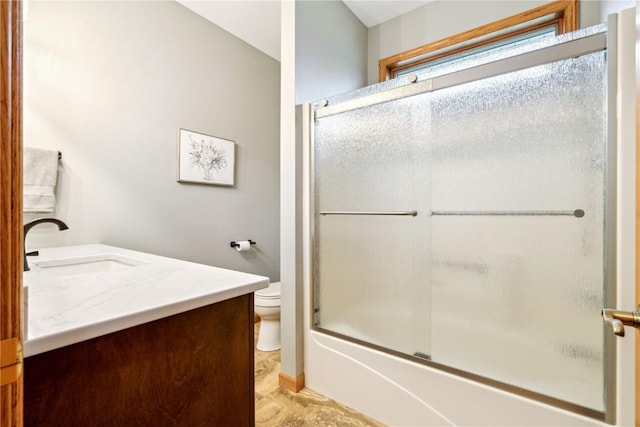 bathroom featuring toilet, vanity, and bath / shower combo with glass door