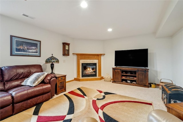 living area with carpet floors, recessed lighting, and a glass covered fireplace