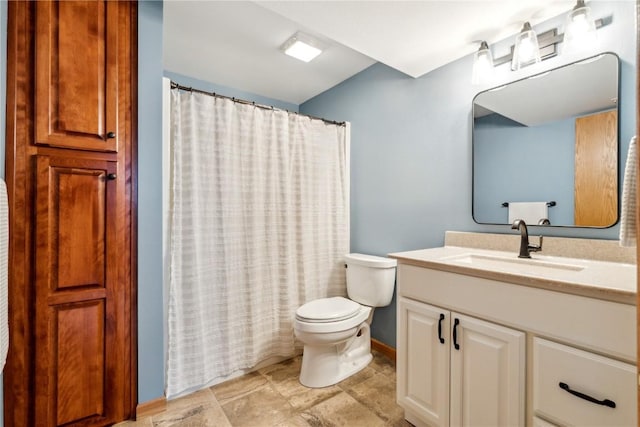 bathroom with toilet, baseboards, vanity, and curtained shower