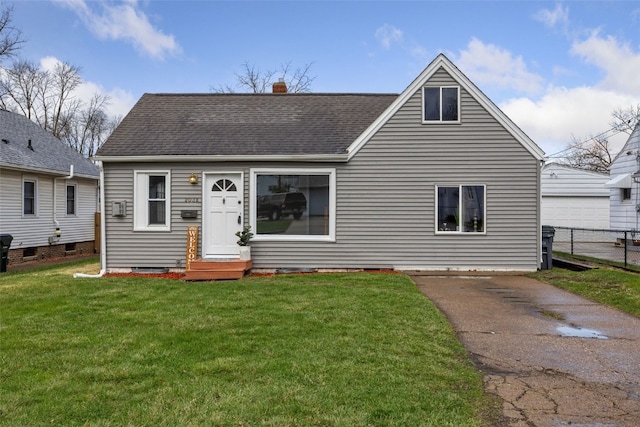 view of front of home with fence, a chimney, roof with shingles, and a front yard