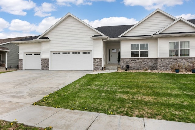 933 Commercial St, Lisbon, IA 52253 - view of front of house with an attached garage, concrete driveway, a front lawn, and stone siding