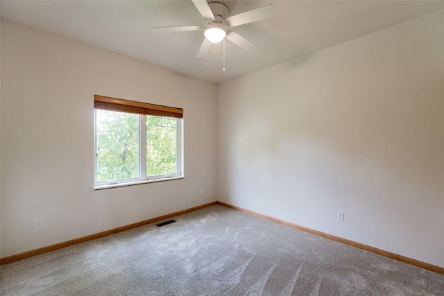 unfurnished room featuring carpet floors, visible vents, a ceiling fan, and baseboards