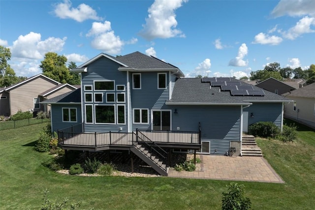 rear view of house with a lawn, a shingled roof, a patio, a wooden deck, and stairs