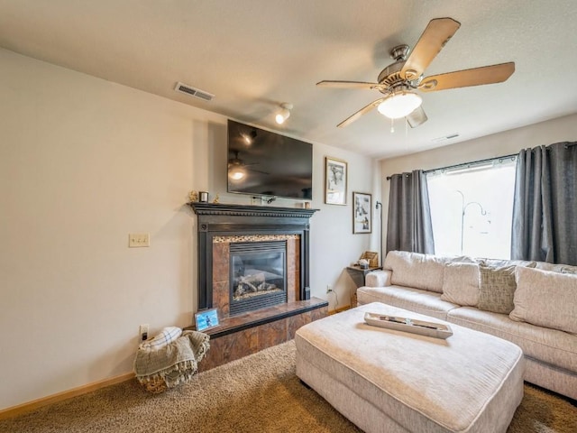 living area featuring a high end fireplace, visible vents, carpet flooring, and ceiling fan