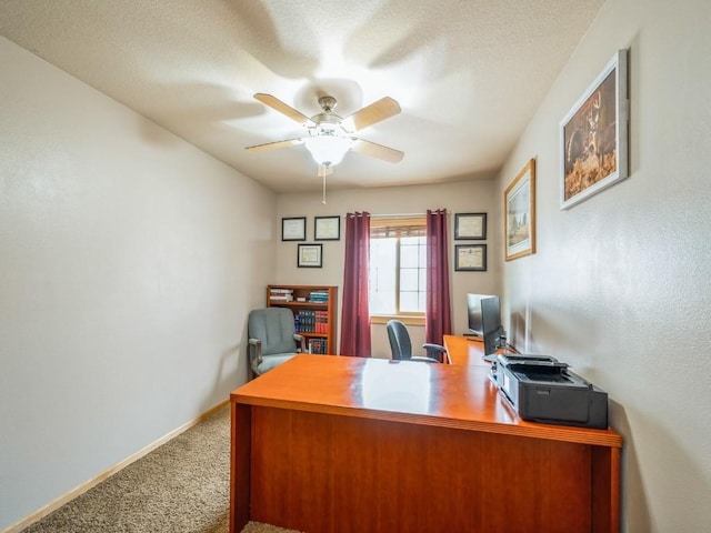 carpeted home office with a ceiling fan and baseboards