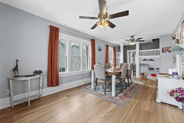 dining space with light wood-style flooring, baseboards, and a ceiling fan