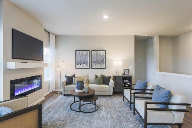 715 Thomas St, Tiffin, IA 52340 - living area featuring recessed lighting, wood finished floors, visible vents, baseboards, and a glass covered fireplace