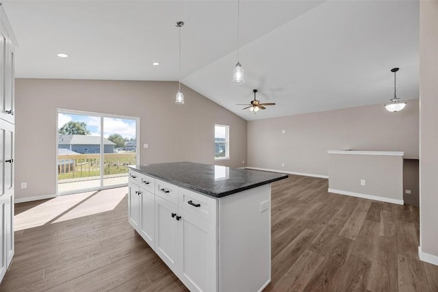kitchen featuring lofted ceiling, white cabinetry, dark wood-type flooring, and a kitchen island