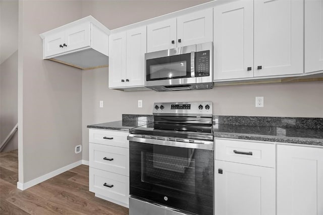 kitchen featuring dark stone counters, stainless steel appliances, white cabinets, baseboards, and dark wood-style flooring