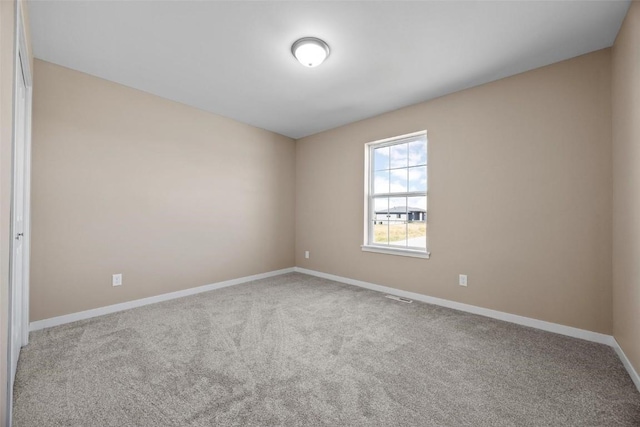 carpeted empty room featuring visible vents and baseboards