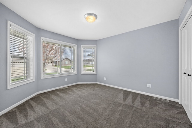 3211 35th Ave, Marion, IA 52302 - unfurnished bedroom featuring baseboards, dark colored carpet, visible vents, and a closet