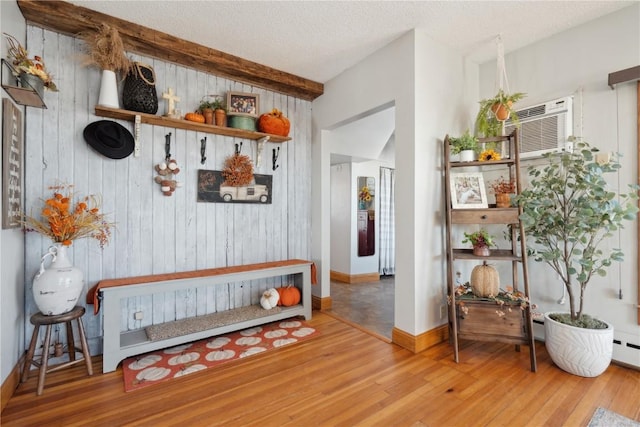 mudroom with wood walls, wood finished floors, baseboards, and a wall mounted AC