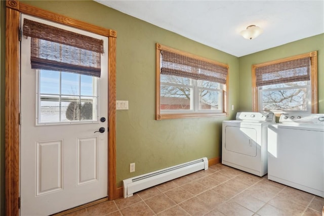 washroom featuring a baseboard heating unit, baseboards, light tile patterned floors, washing machine and clothes dryer, and laundry area