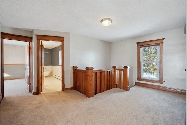 interior space with carpet floors, baseboard heating, and plenty of natural light