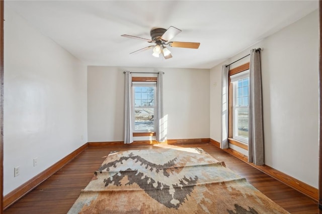 empty room with baseboards, a healthy amount of sunlight, and wood finished floors