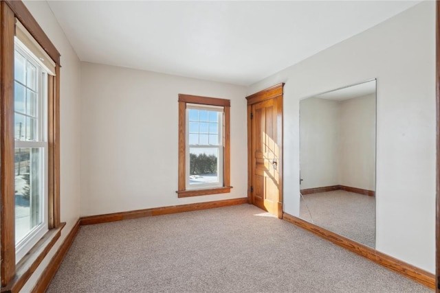 carpeted empty room featuring baseboards