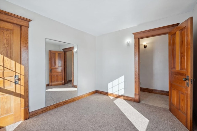 carpeted spare room featuring baseboards