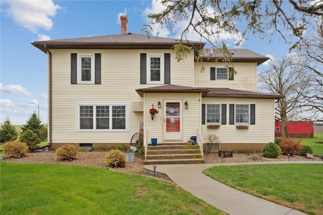 traditional-style house featuring a front lawn and a chimney