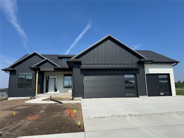 5556 Silver Rock Dr, Marion, IA 52302 - view of front of home with a garage, concrete driveway, a standing seam roof, board and batten siding, and metal roof