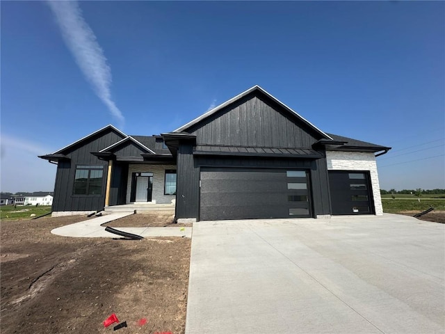 5556 Silver Rock Dr, Marion, IA 52302 - view of front of property featuring a standing seam roof, a garage, concrete driveway, metal roof, and board and batten siding