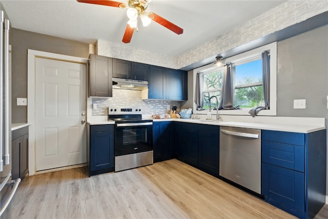 404 Main St, Shellsburg, IA 52332 - kitchen with a sink, stainless steel appliances, blue cabinetry, and under cabinet range hood