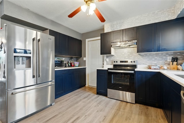 404 Main St, Shellsburg, IA 52332 - kitchen with under cabinet range hood, stainless steel appliances, light wood-style flooring, and light countertops