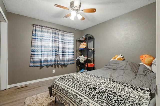 404 Main St, Shellsburg, IA 52332 - bedroom featuring baseboards, a textured ceiling, a textured wall, and wood finished floors