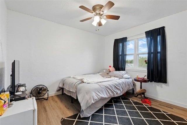 404 Main St, Shellsburg, IA 52332 - bedroom with baseboards, ceiling fan, wood finished floors, and visible vents