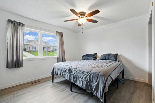 404 Main St, Shellsburg, IA 52332 - bedroom with visible vents, a ceiling fan, baseboards, and wood finished floors