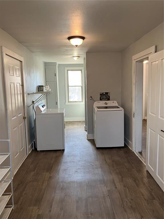 laundry room featuring dark wood-style floors, separate washer and dryer, laundry area, and baseboards