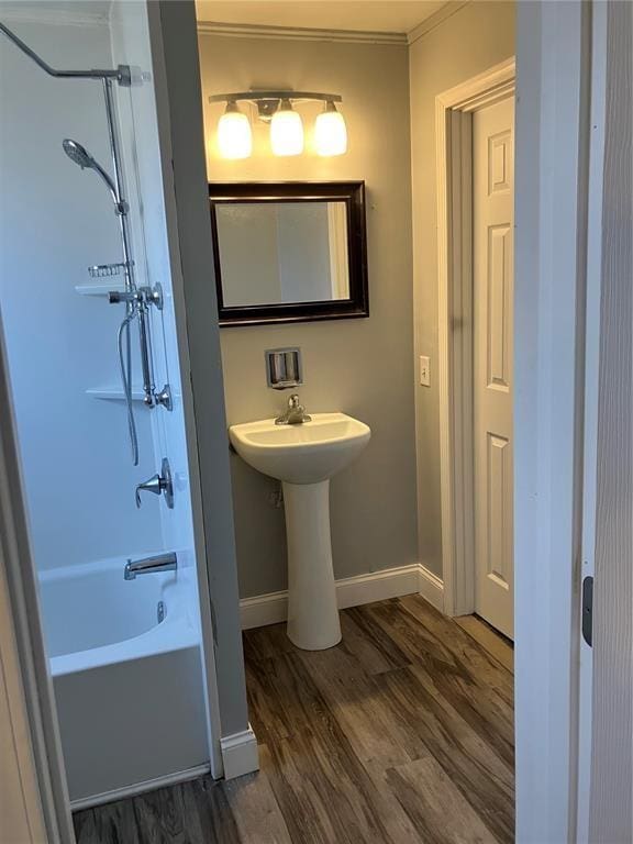 full bath with shower / bathing tub combination, wood finished floors, crown molding, and baseboards
