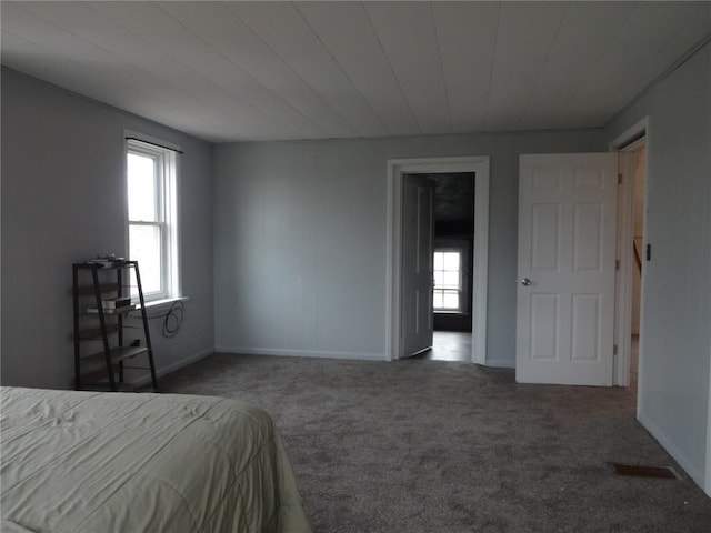 bedroom featuring carpet flooring, multiple windows, and baseboards
