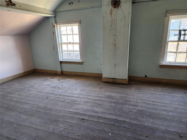 bonus room featuring lofted ceiling, hardwood / wood-style floors, and baseboards