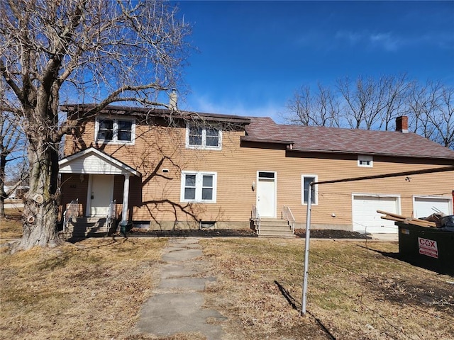 view of front of home with a chimney, entry steps, and a garage