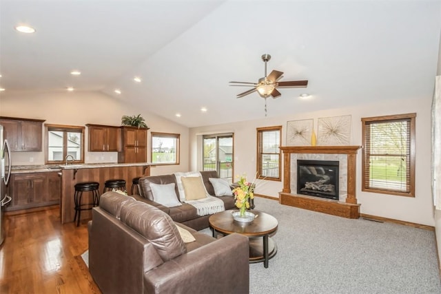 living area with recessed lighting, a fireplace, ceiling fan, baseboards, and lofted ceiling