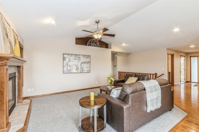 living room featuring recessed lighting, vaulted ceiling, a glass covered fireplace, baseboards, and a ceiling fan