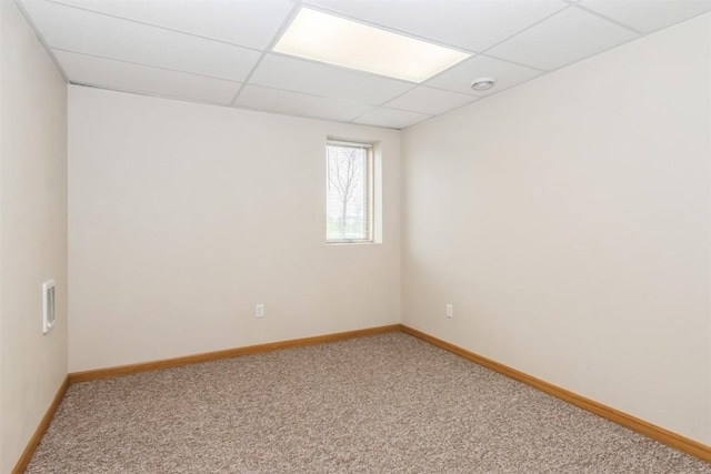 empty room with baseboards, light carpet, and a paneled ceiling