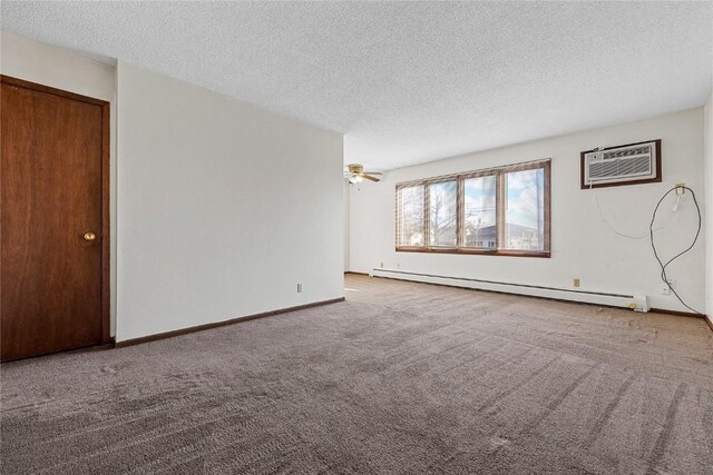 3212 Wilson Ave SW, Cedar Rapids, IA 52404 - carpeted empty room with a baseboard heating unit, a wall unit AC, a textured ceiling, and baseboards