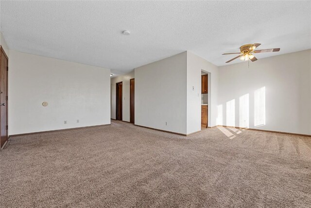 3212 Wilson Ave SW, Cedar Rapids, IA 52404 - spare room featuring light colored carpet, ceiling fan, baseboards, and a textured ceiling
