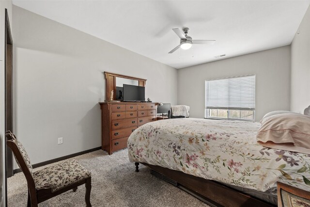 bedroom with a ceiling fan, visible vents, light colored carpet, and baseboards