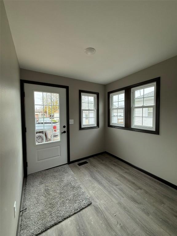 305 E 5th St, Vinton, IA 52349 - foyer entrance with light wood finished floors, visible vents, and baseboards